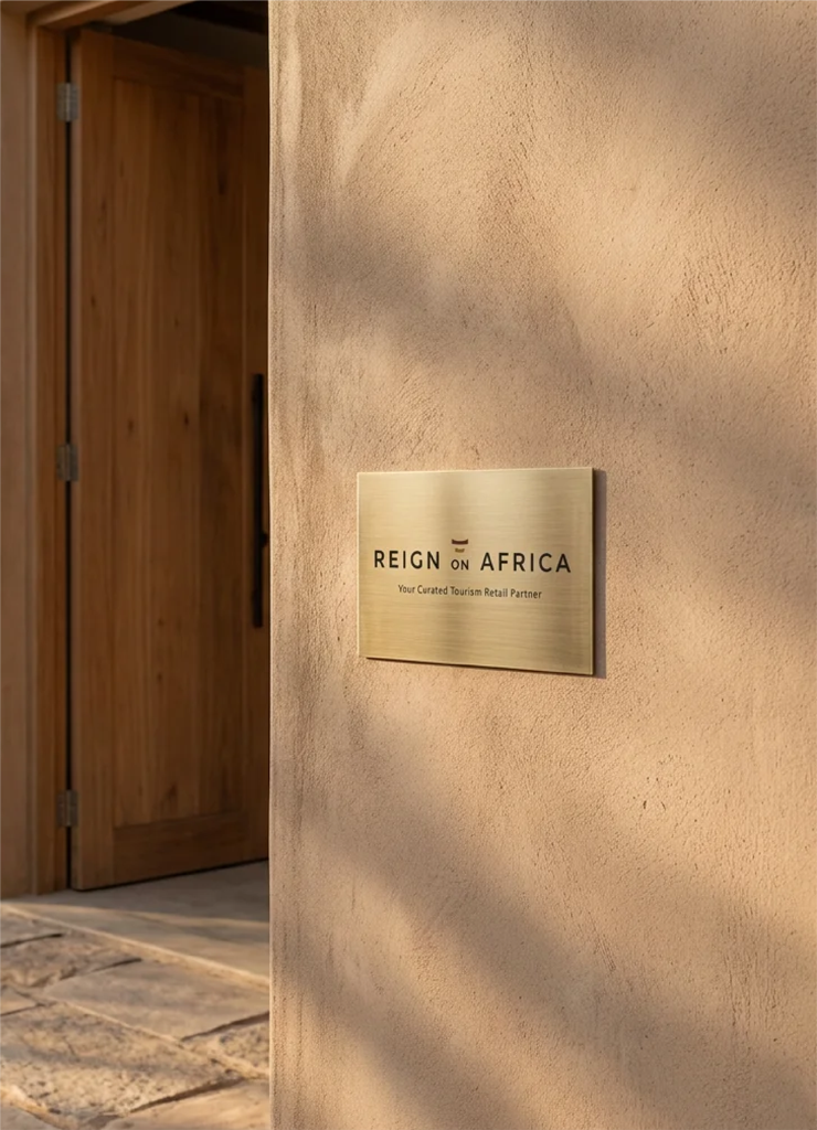 Reign On Africa brass plate signage featuring the logo and the tagline Your Curated Tourism Retail Partner